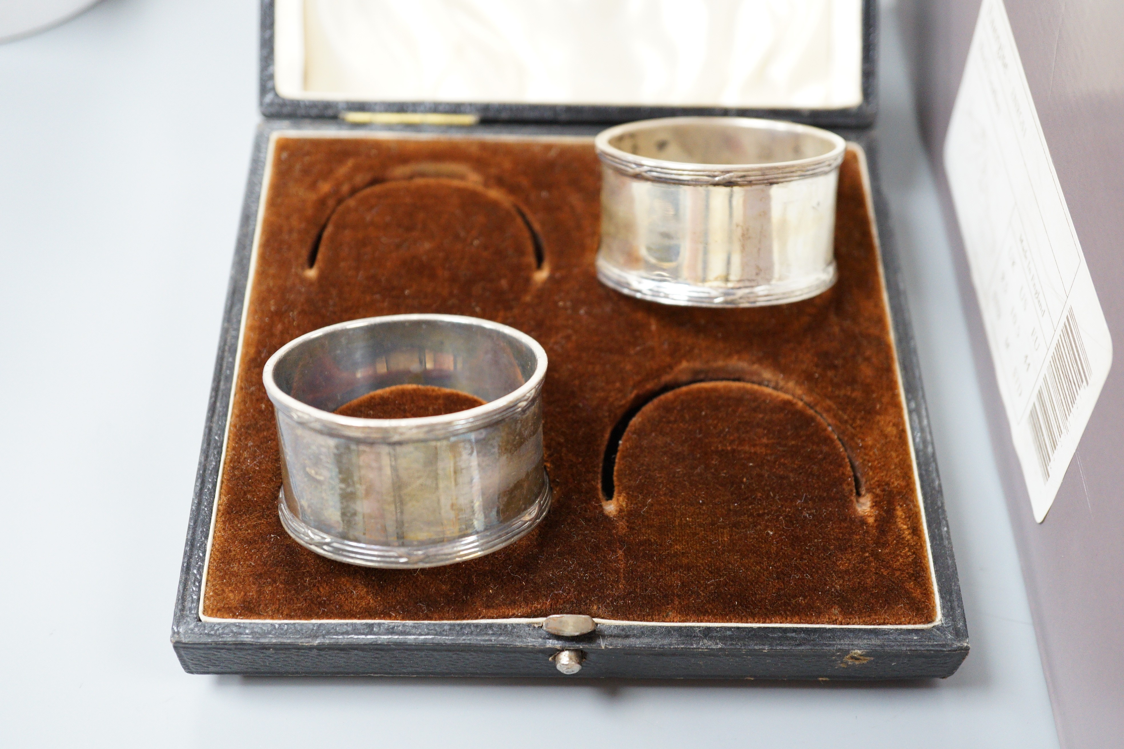 Assorted silver wares to include a George V toast rack, Birmingham, 1934, napkins rings, weighted dwarf candlesticks, cigarette case, condiments, an Edwardian desk stand and a Victorian Irish two handled sugar bowl jar,